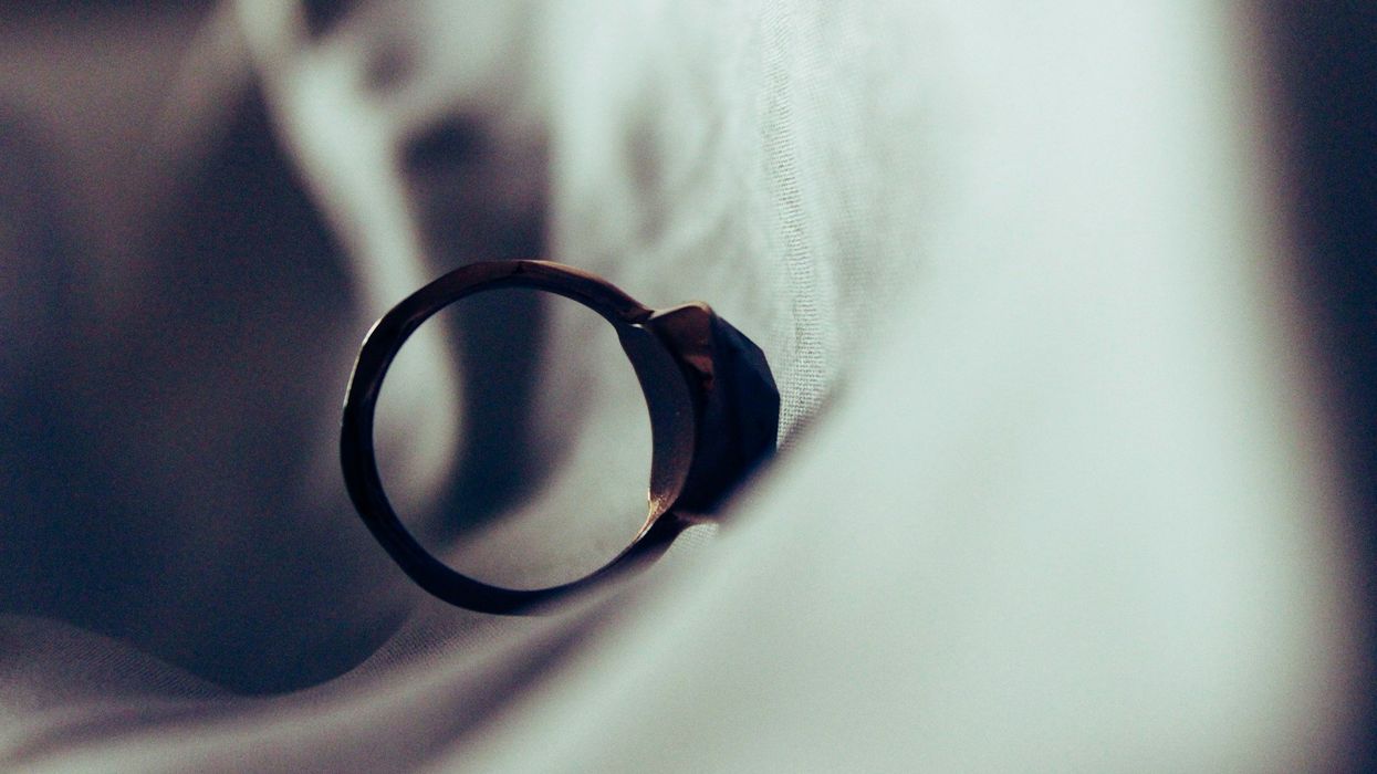 An engagement ring falls down a sheet