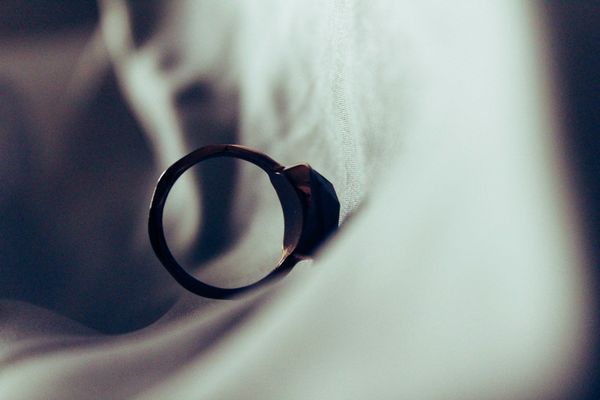 An engagement ring falls down a sheet