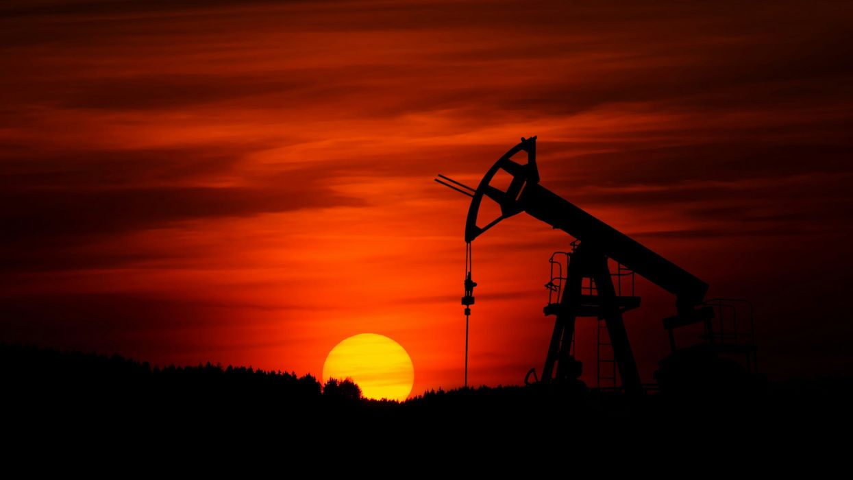 An oil rig in front of a setting sun