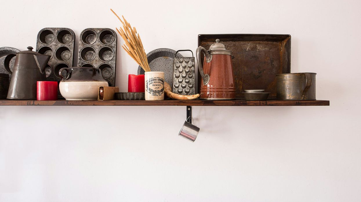 antique kitchen utensil lot on brown wooden floating shelf