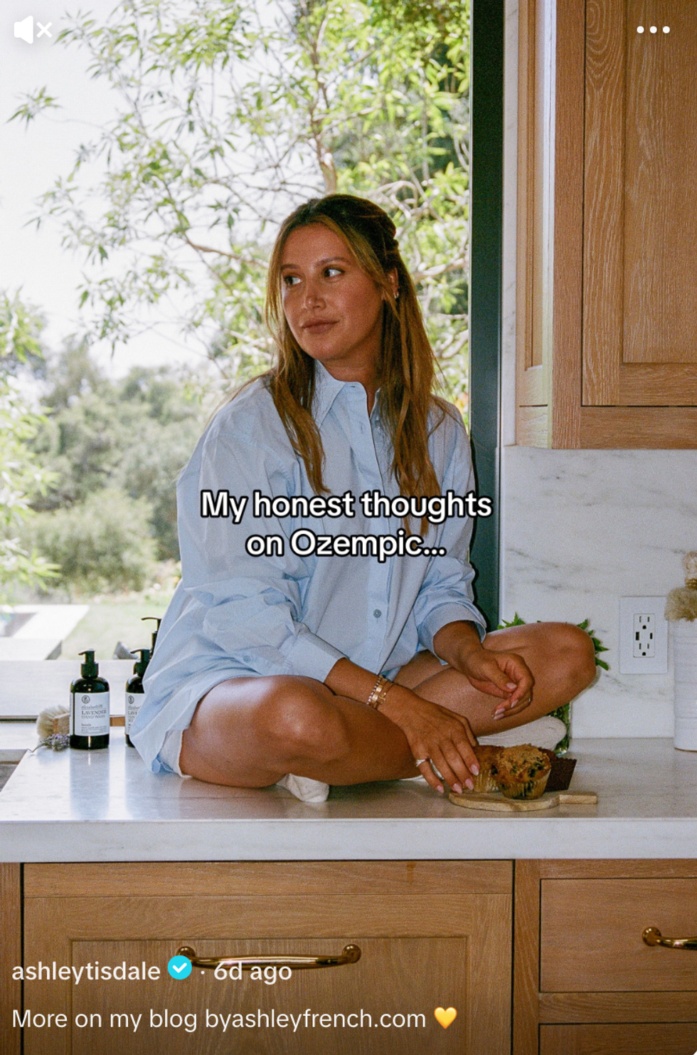 Ashley Tisdale sitting on a kitchen counter with a text overlay.