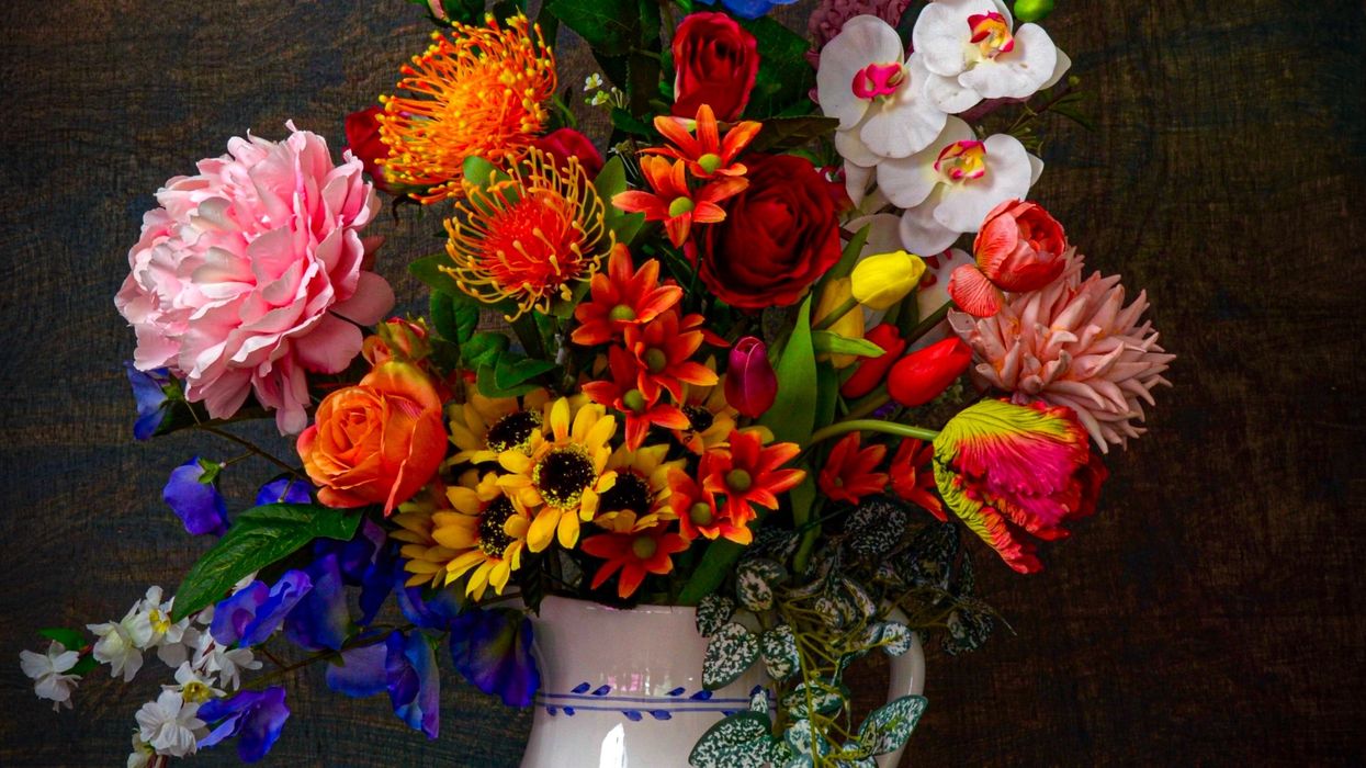 assorted flowers in white vase on brown surface