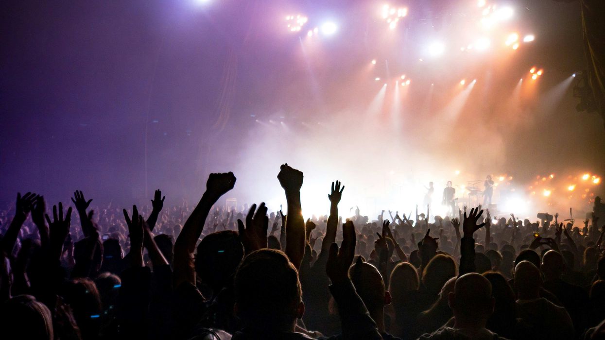 Audience members with arms in the air at a concert