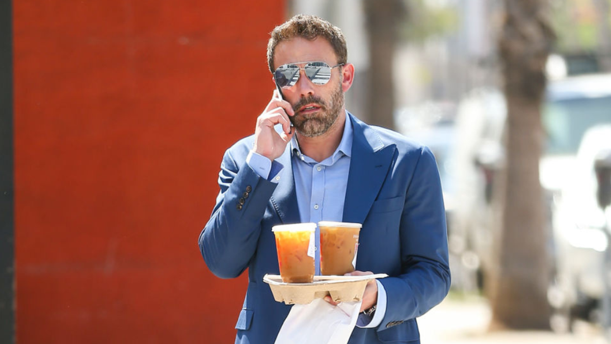 Ben Affleck on cell phone and holding Dunkin Donuts coffee