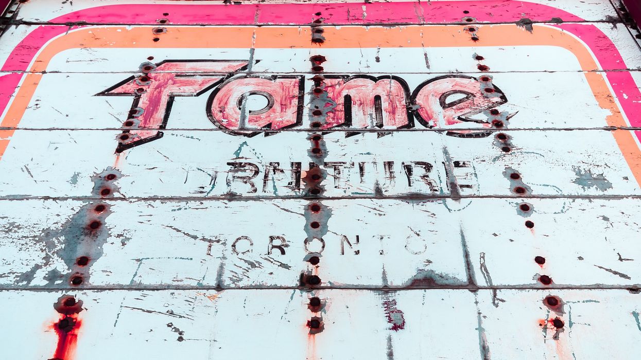 black and red Fame graffiti on white metal surface