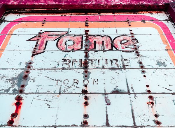 black and red Fame graffiti on white metal surface