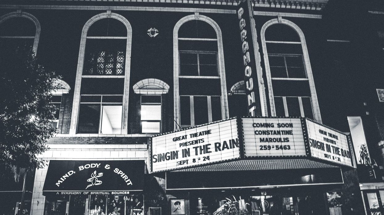 Black and white photo of a movie theater showing "Singing in the Rain"