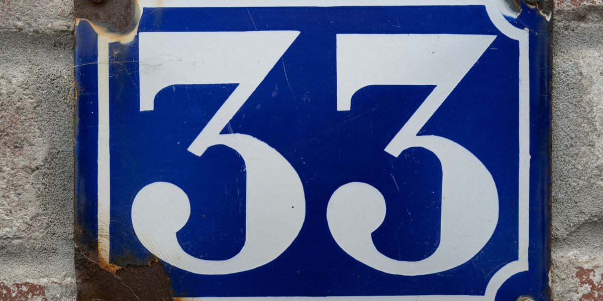 blue and white 33 on a brick wall