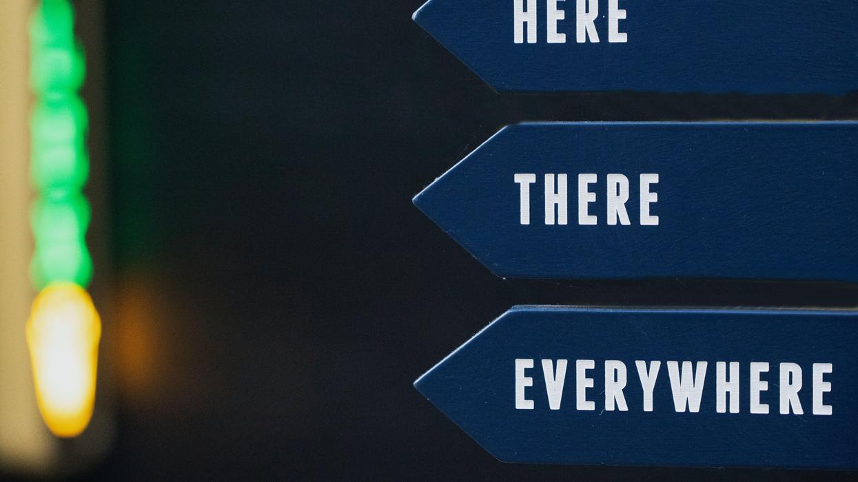 Blue pointed signs that read, "Here, There, Everywhere"