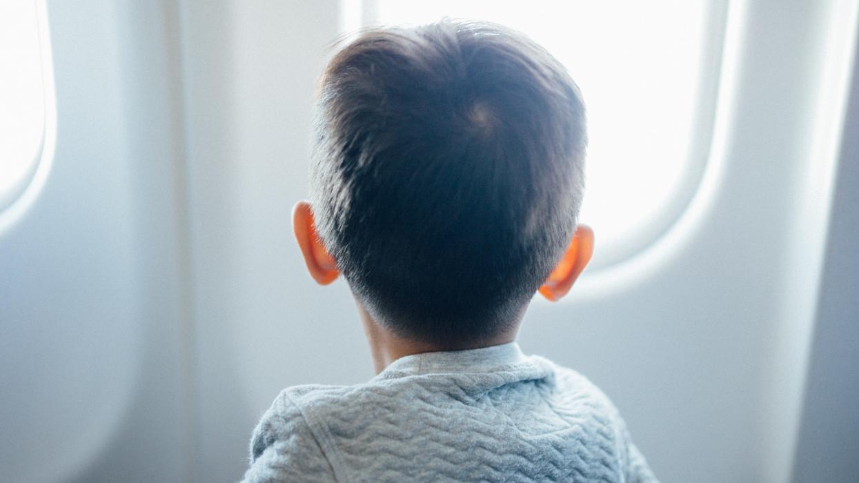 Boy looking out an airplane window.
