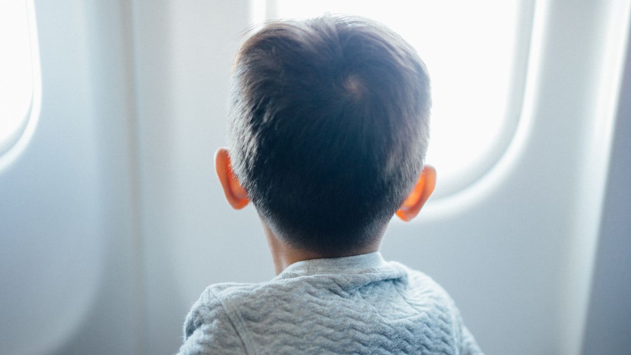 Boy looking out an airplane window.