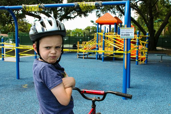boy riding red bicycle