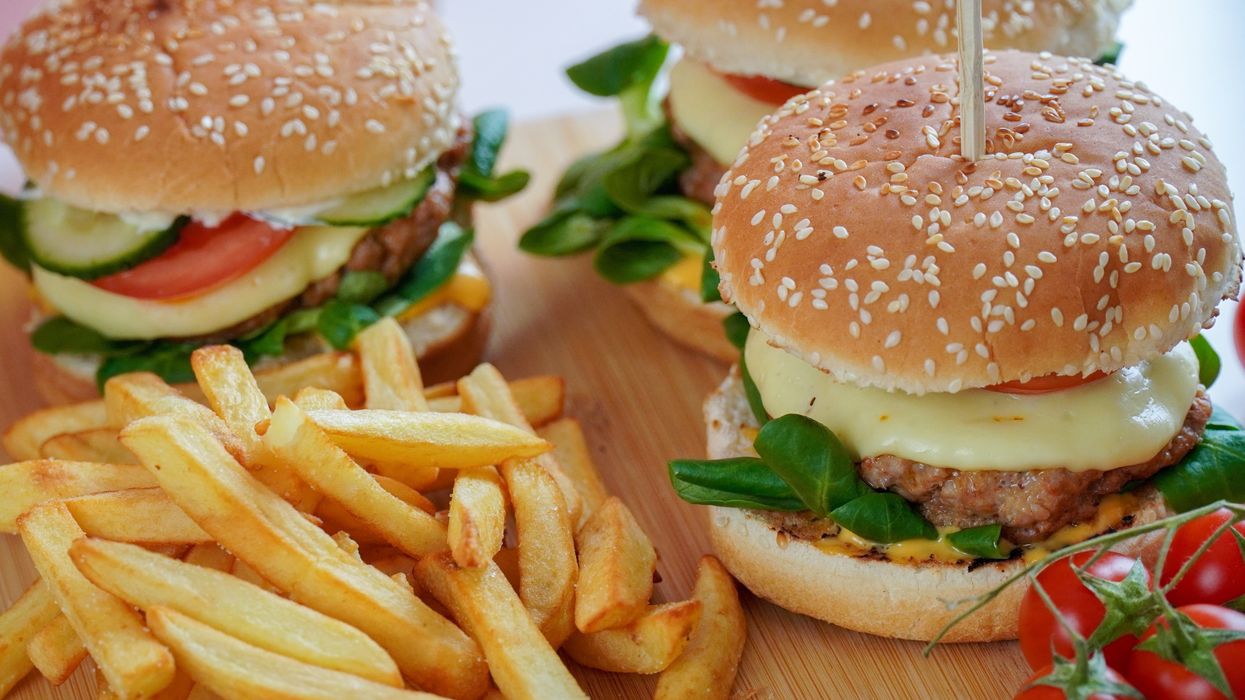 burger with lettuce and fries on brown wooden table