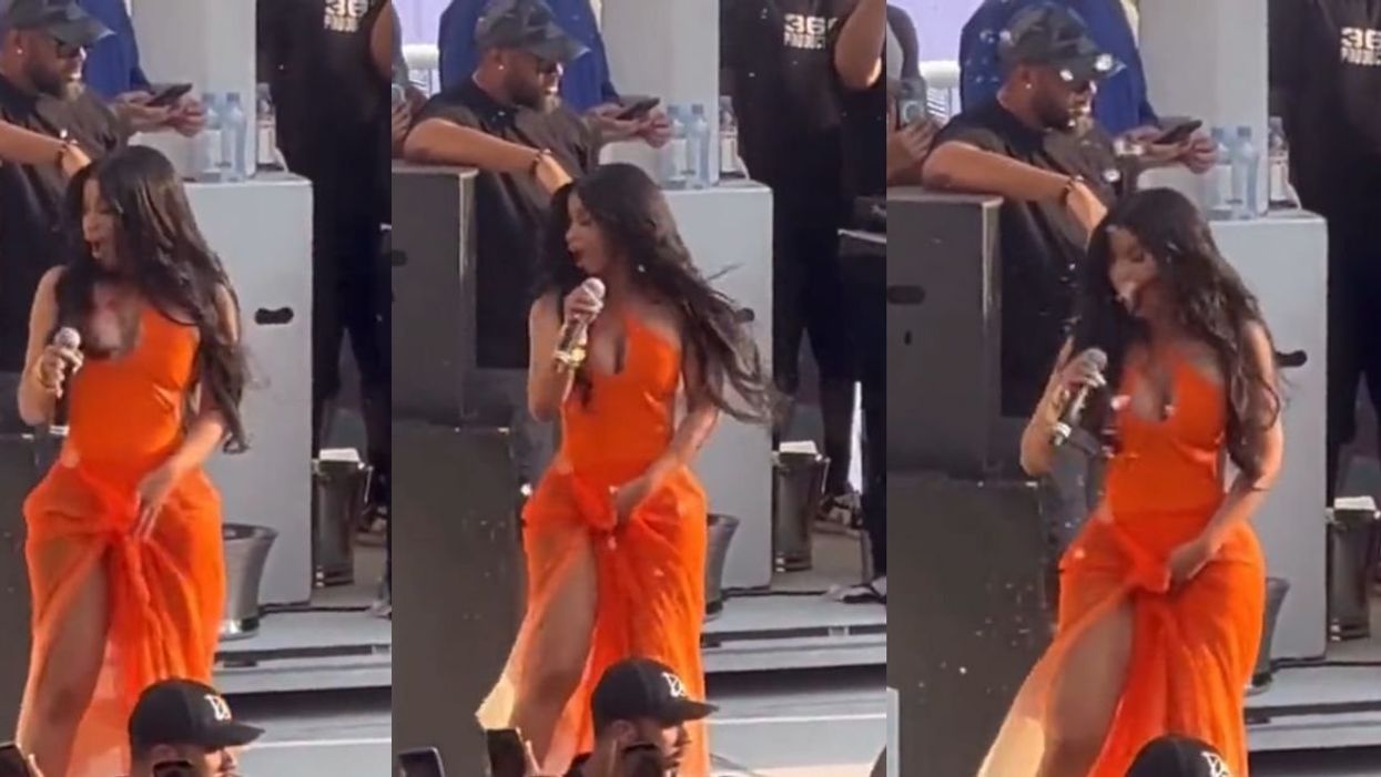 Cardi B getting splashed with a beverage at a concert