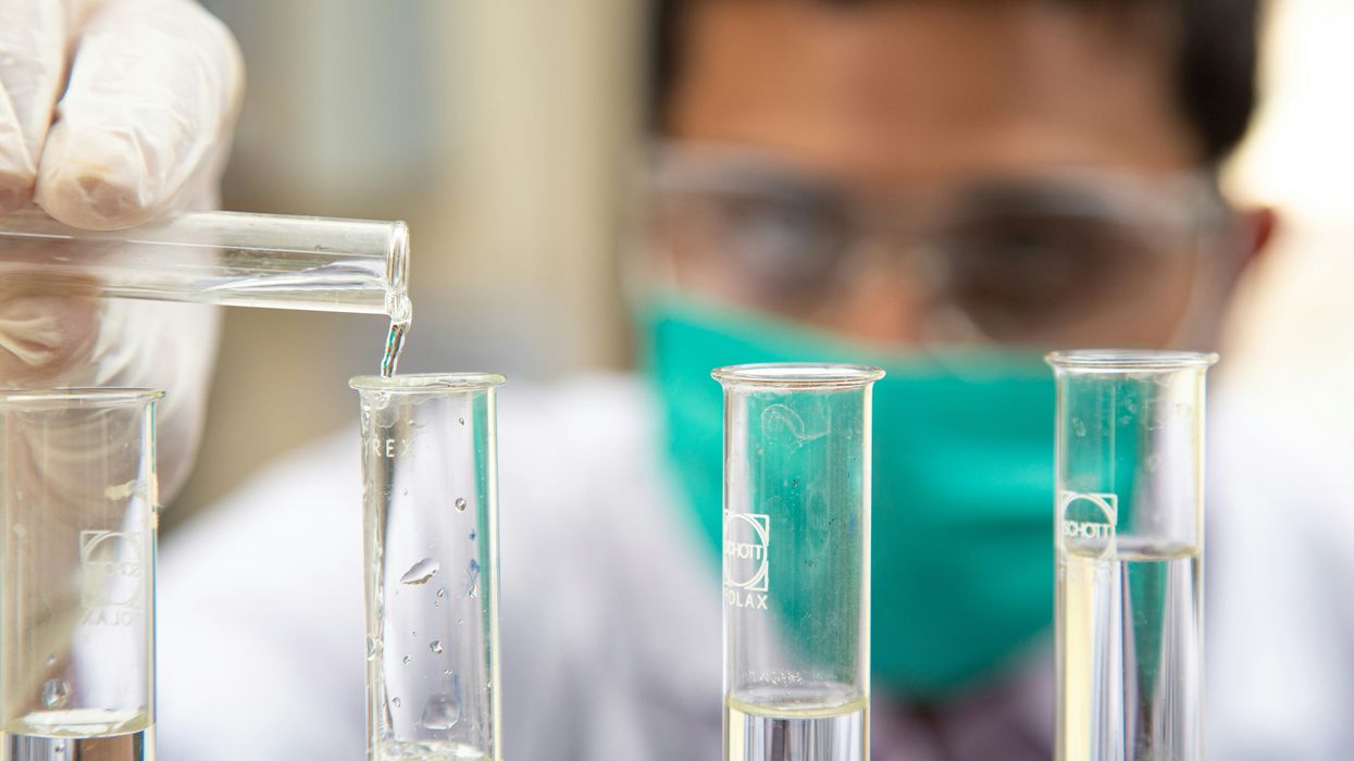 Chemist filling vials with fluid