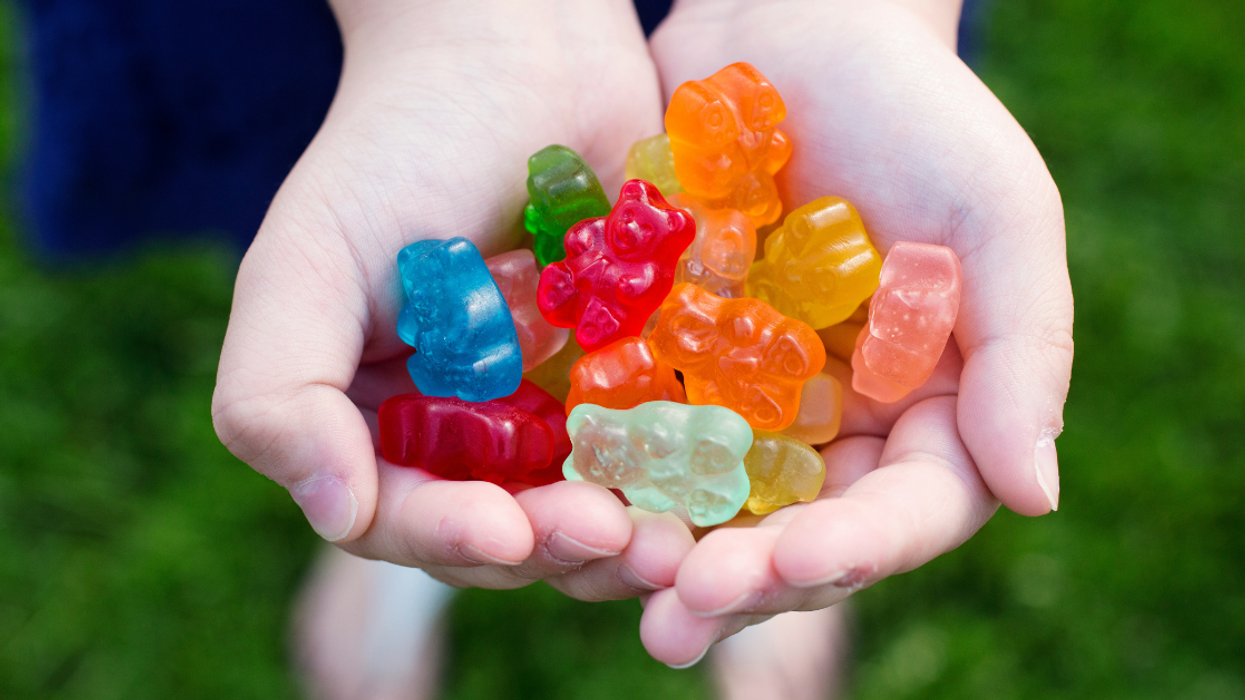 child holding two handfuls of gummy bears