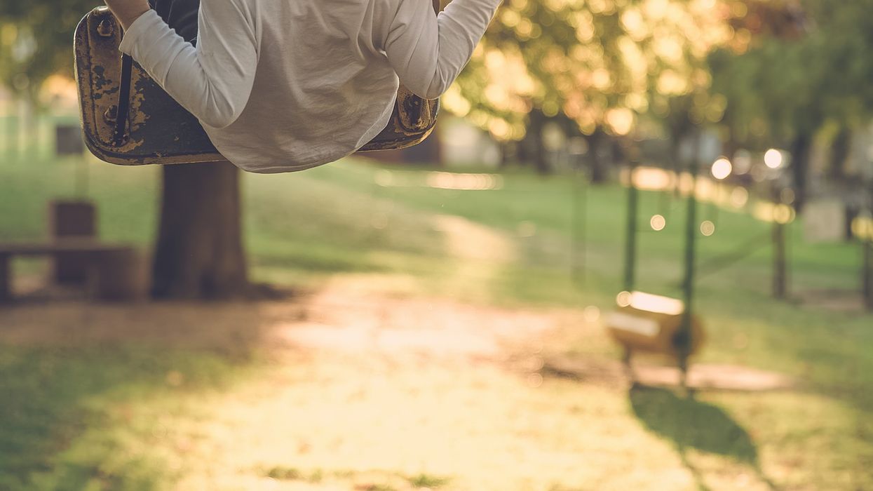 Child on swings in golden sunlight
