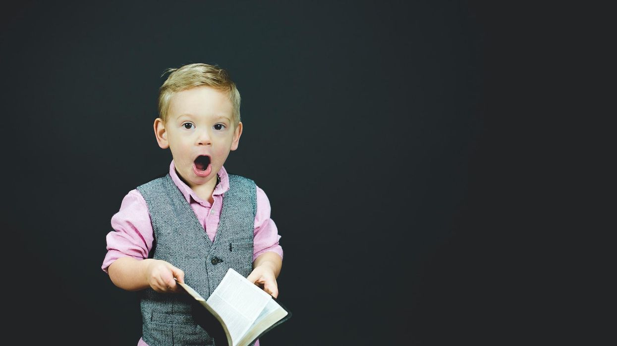child with shocked expression holding leather bound journal