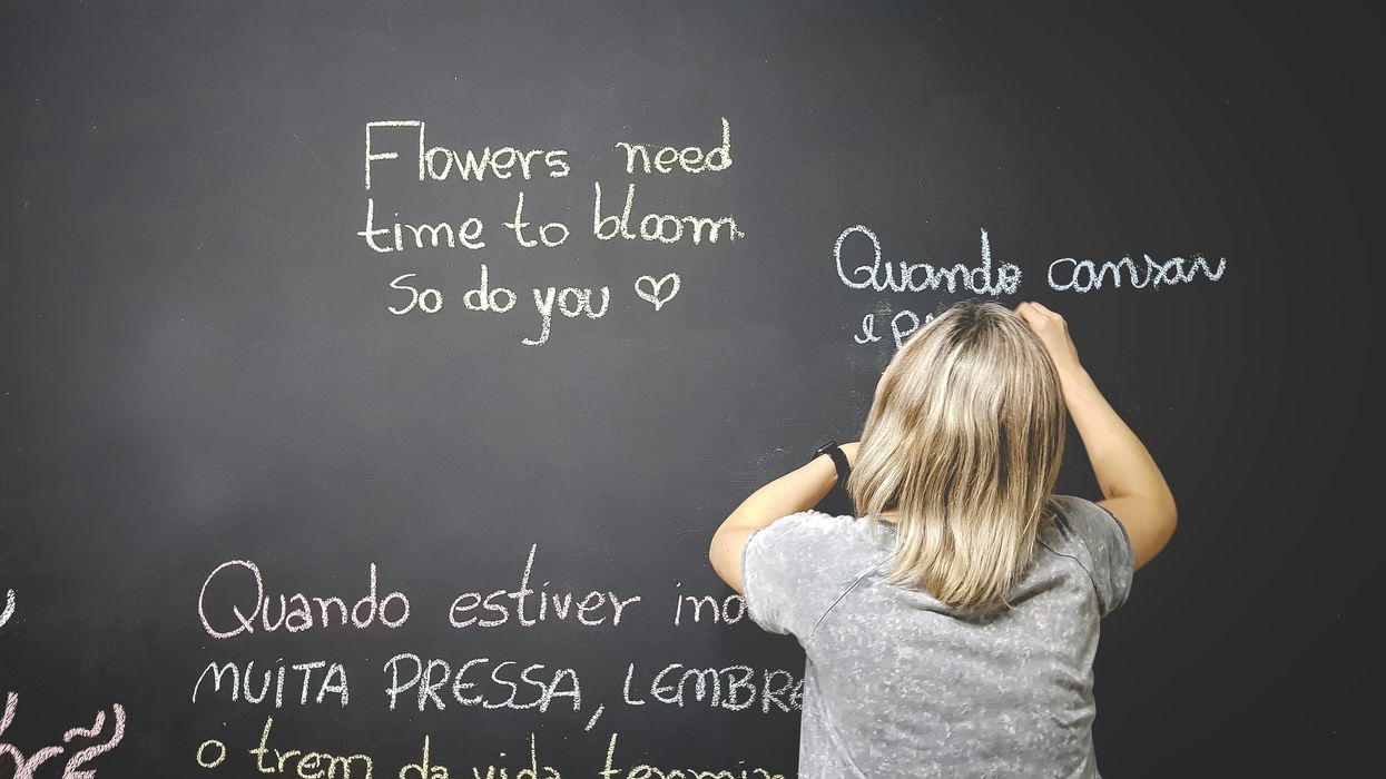 child writing on chalkboard