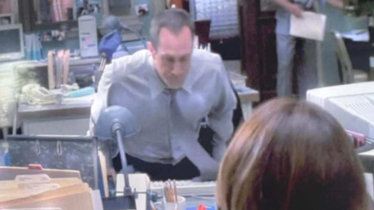 Christopher Meloni as Elliot Stabler leans over a desk in Law & Order: Special Victims Unit.