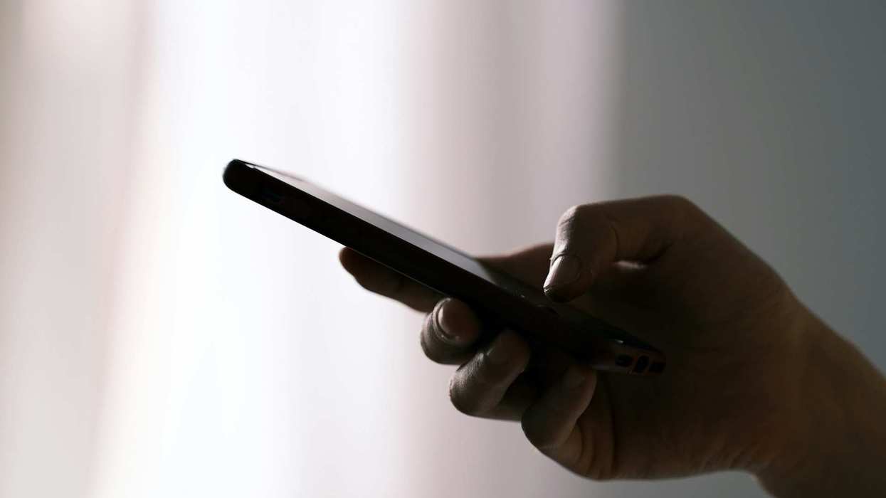 Close-up of an unrecognizable hand texting on a phone.