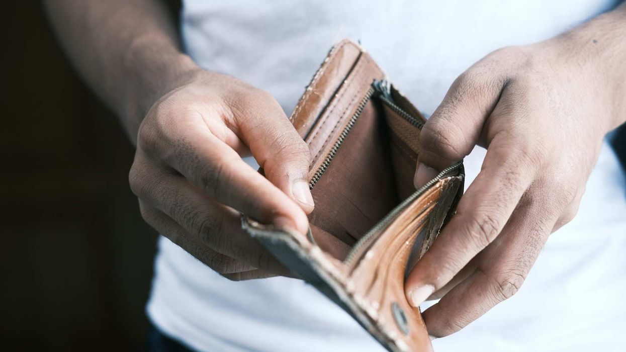 Close-up shot of a man's hands opening his empty wallet.
