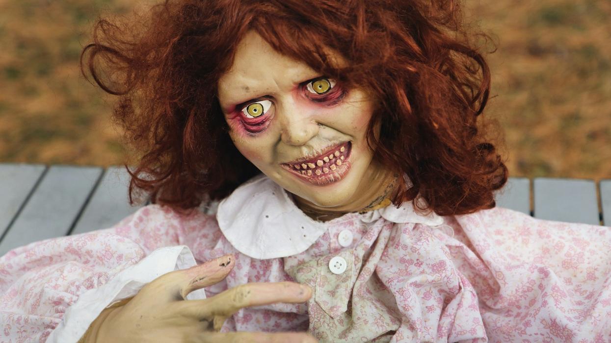Close-up shot of ghoulish doll. She has red hair and skeletal features.