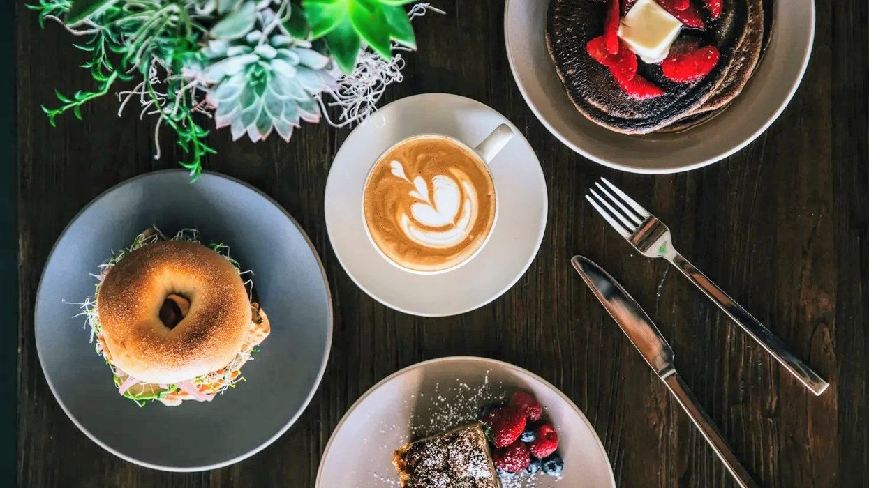 coffee with latte art surrounded by breakfast foods