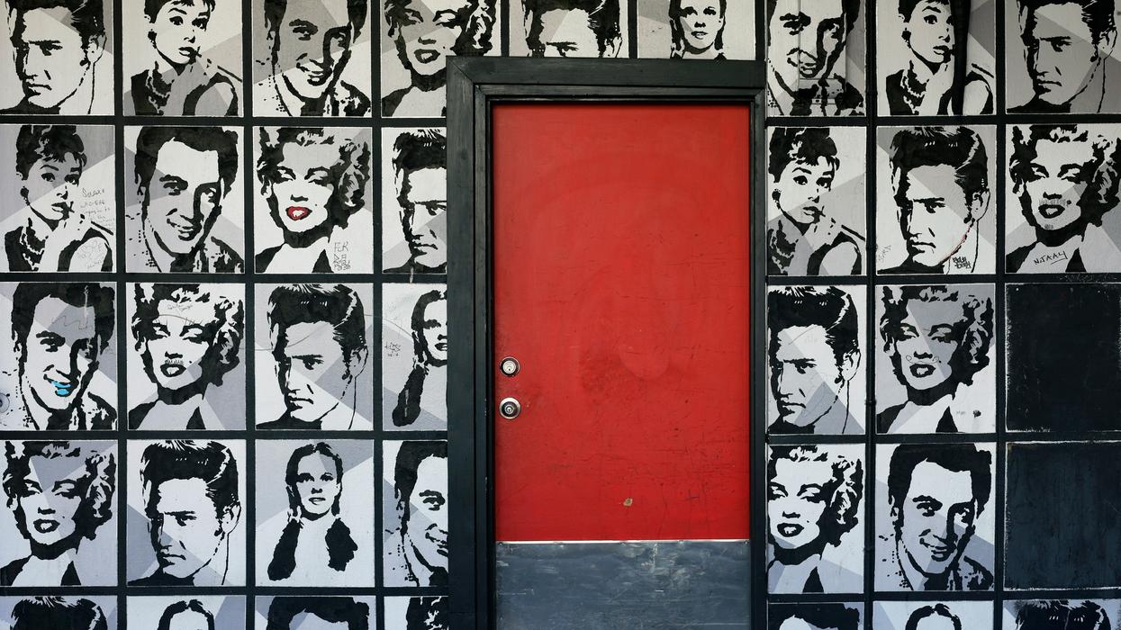 Collage of celebrity photos on a wall around a red door