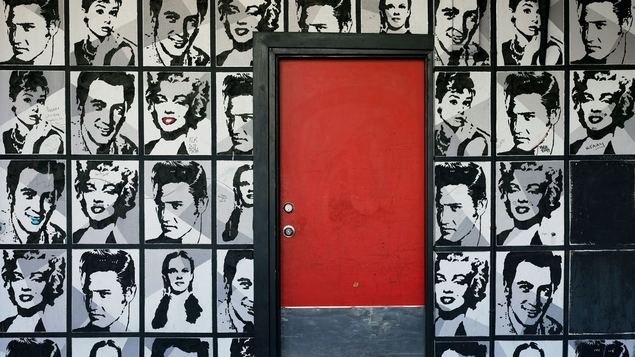 Collage of celebrity photos on a wall around a red door