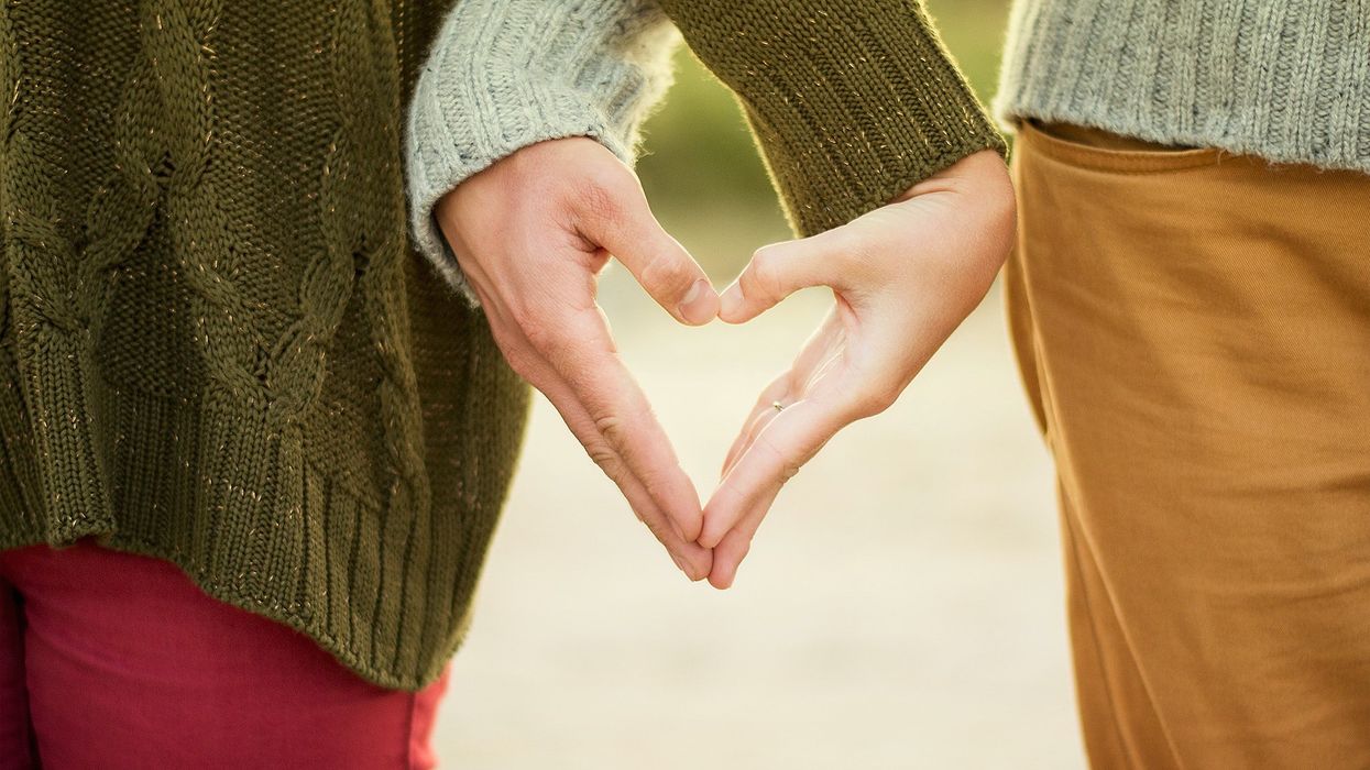 Couple forming heart shape with hands