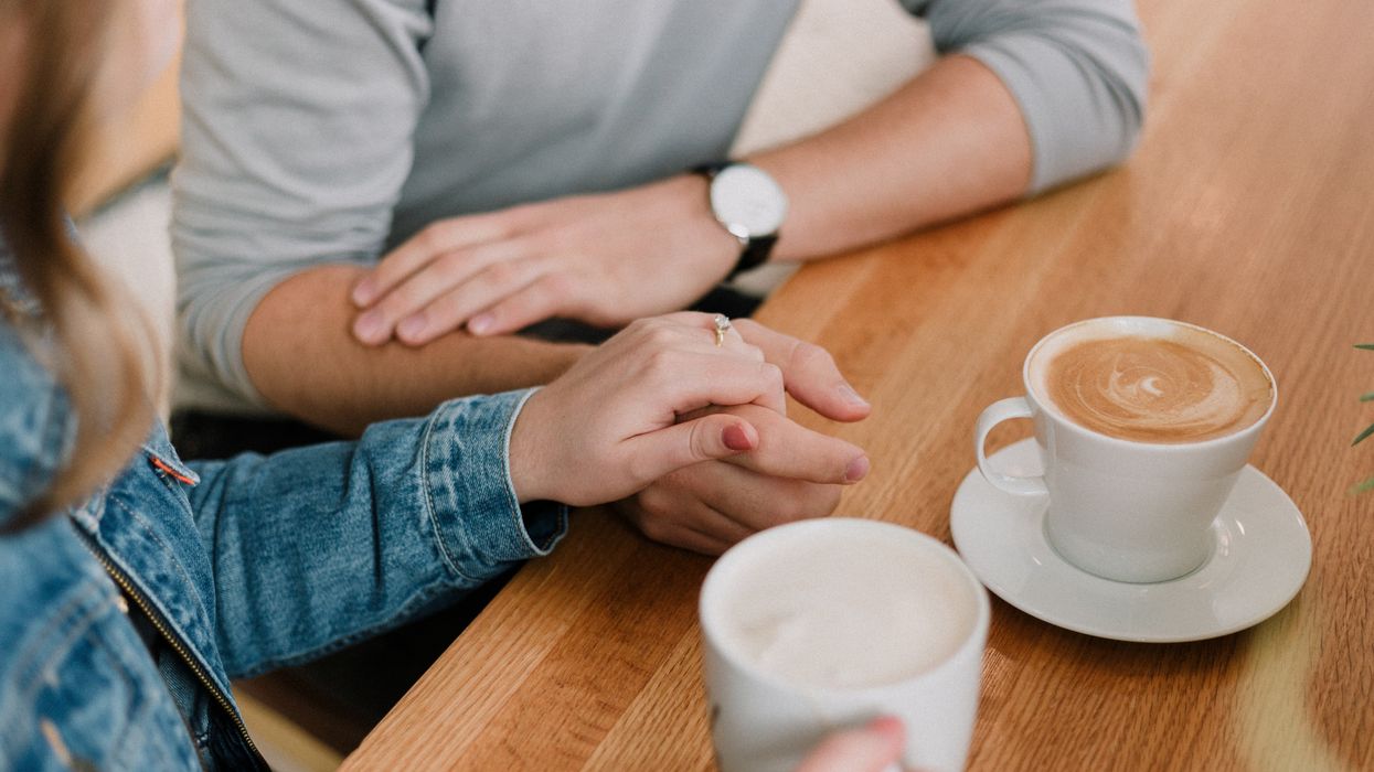 Couple holding hands having coffee