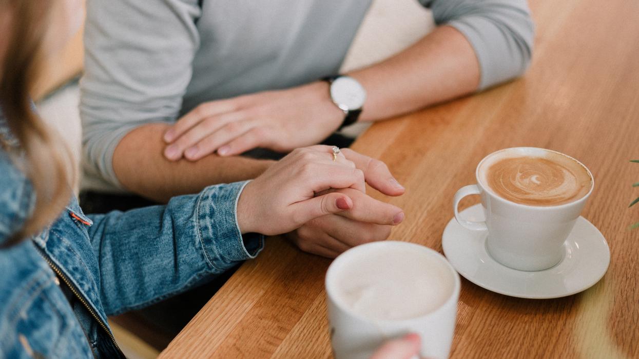 Couple holding hands having coffee
