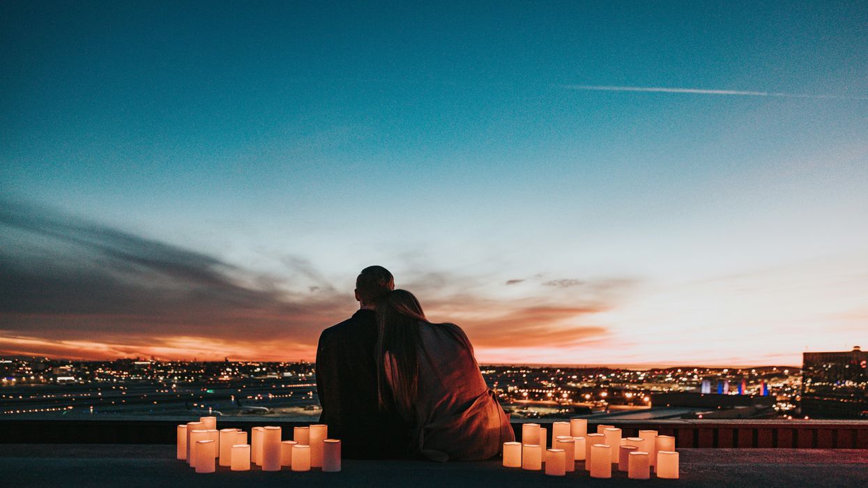 couple sitting on the field facing the city