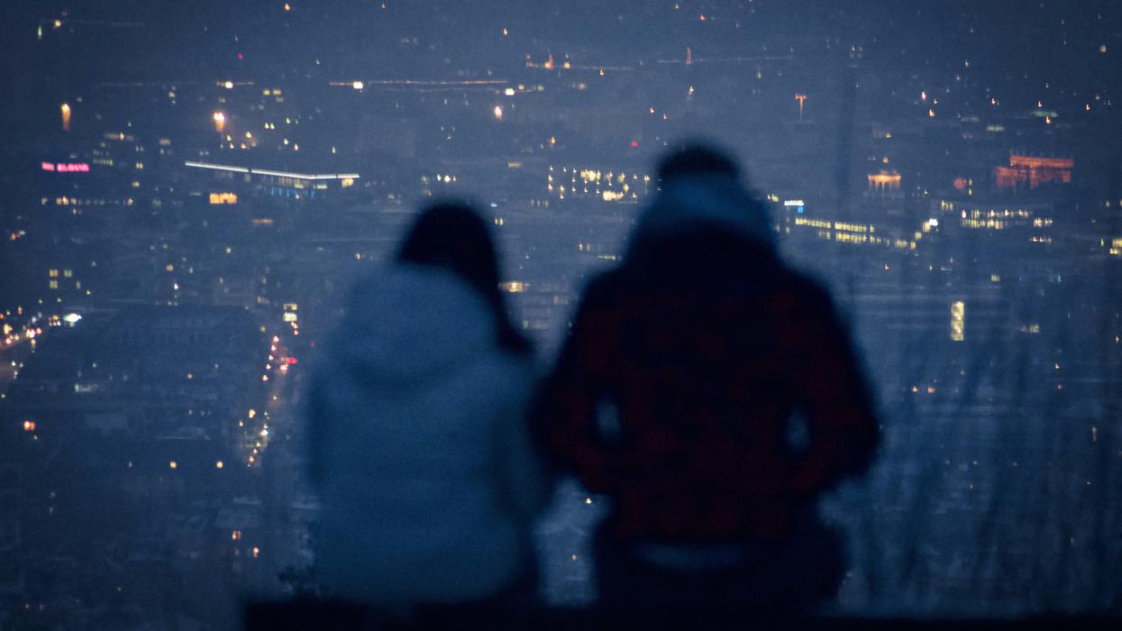 Couple sitting together watching city view at night