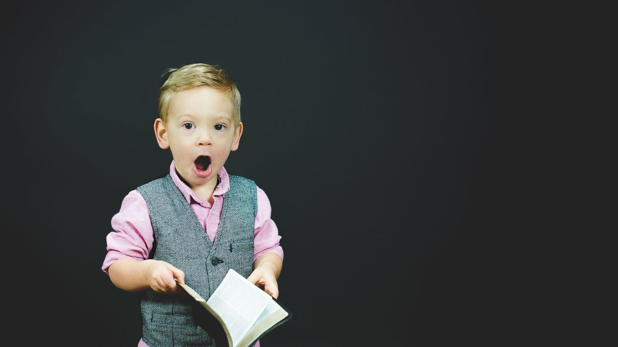 Dapper little boy shocked by what he reads in book