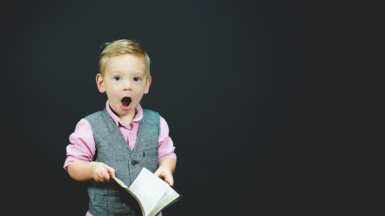 Dapper little boy shocked by what he reads in book
