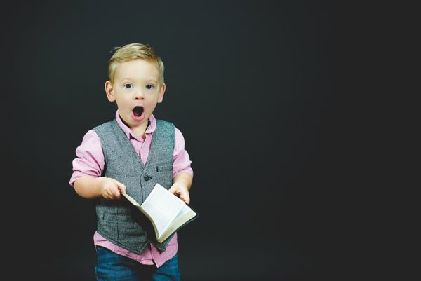 Dapper little boy shocked by what he reads in book