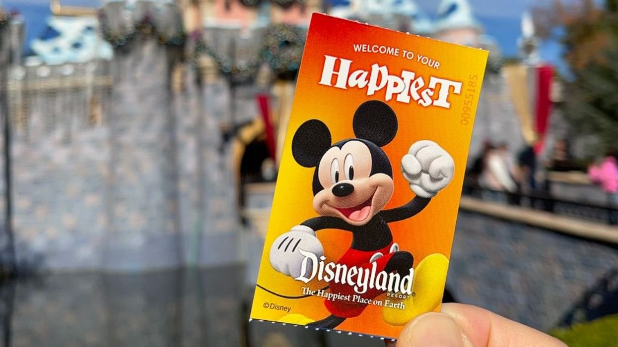 Disneyland park ticket in front of Sleeping Beauty Castle