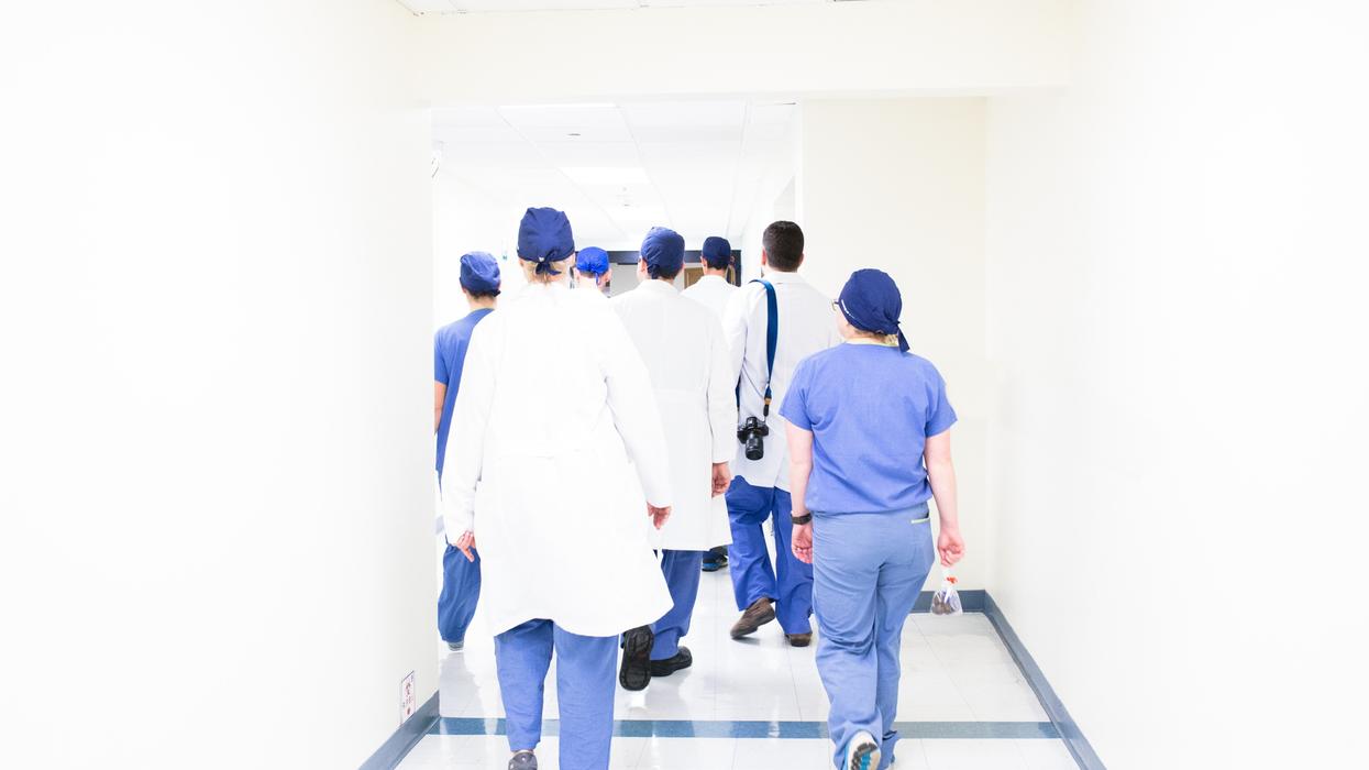 Doctors in medical scrubs walking down a hallway.