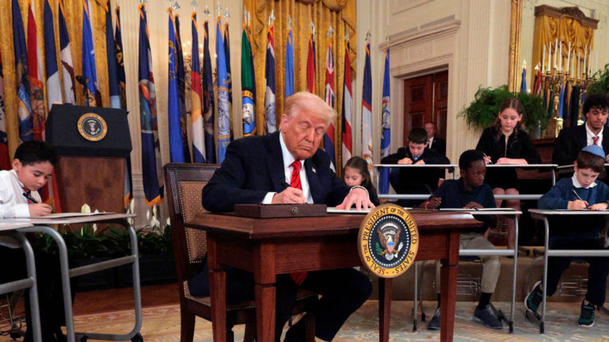 Donald Trump signing executive order flanked by children "signing" the same thing