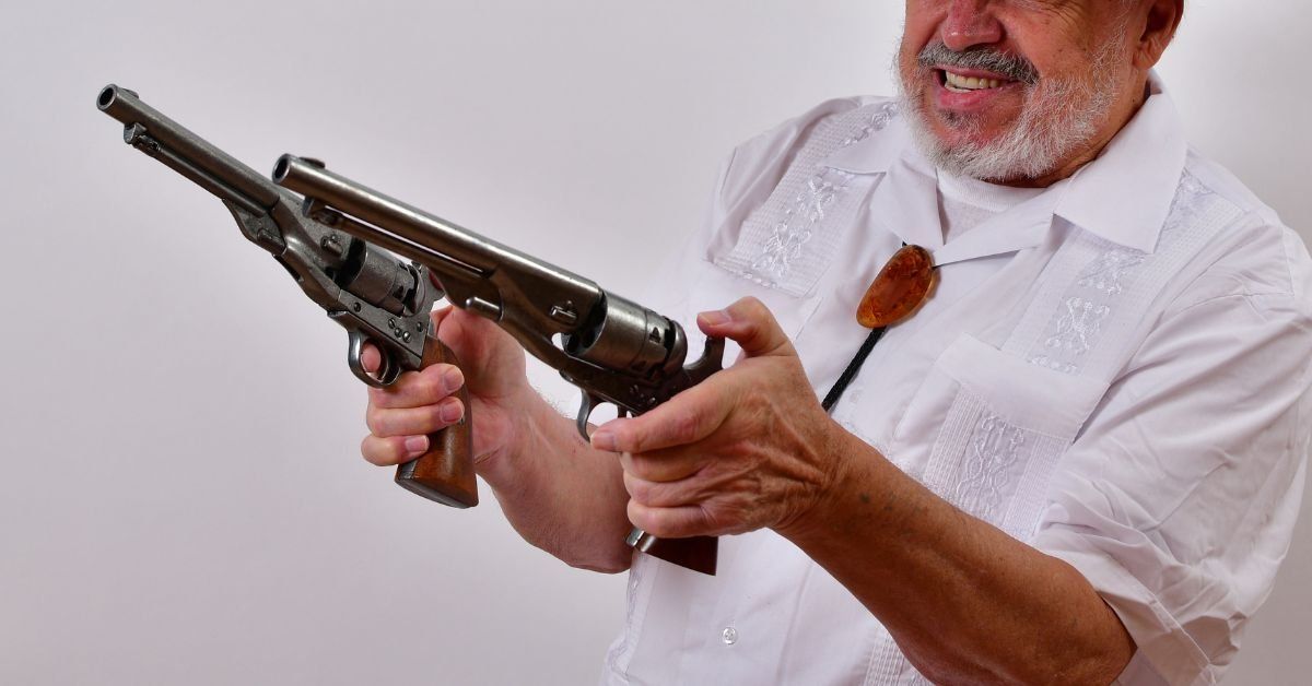 Elderly man holding guns