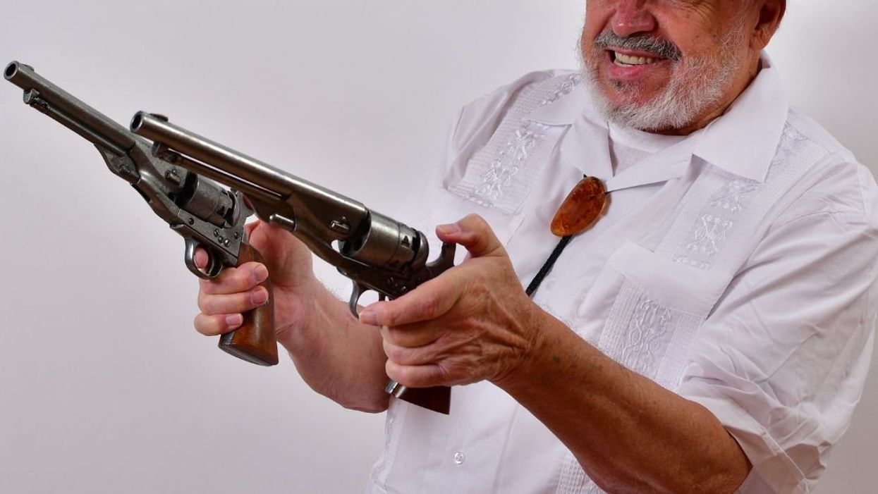 Elderly man holding guns