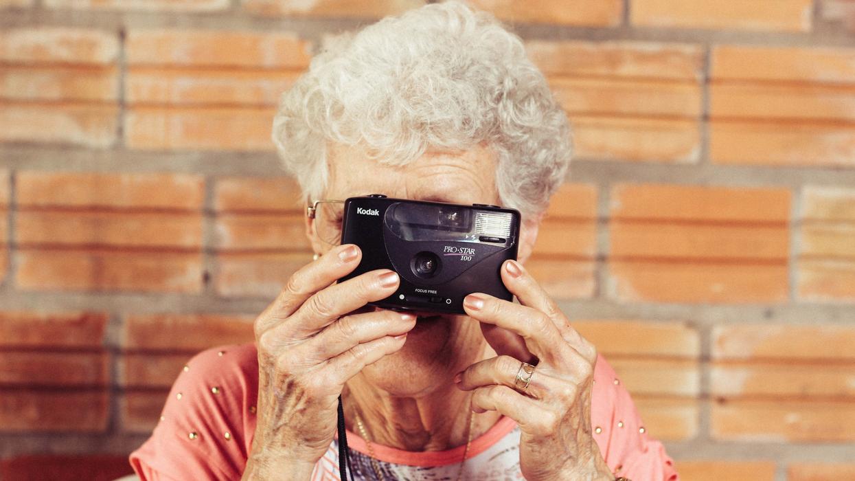 Elderly woman holding Kodak film camera