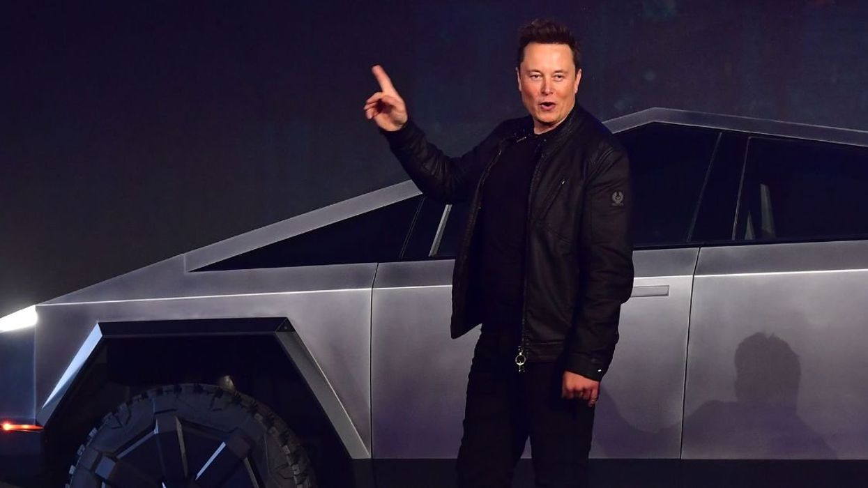Elon Musk standing next to a Cybertruck
