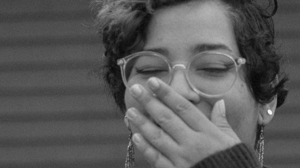 Embarrassed woman covering her face and laughing