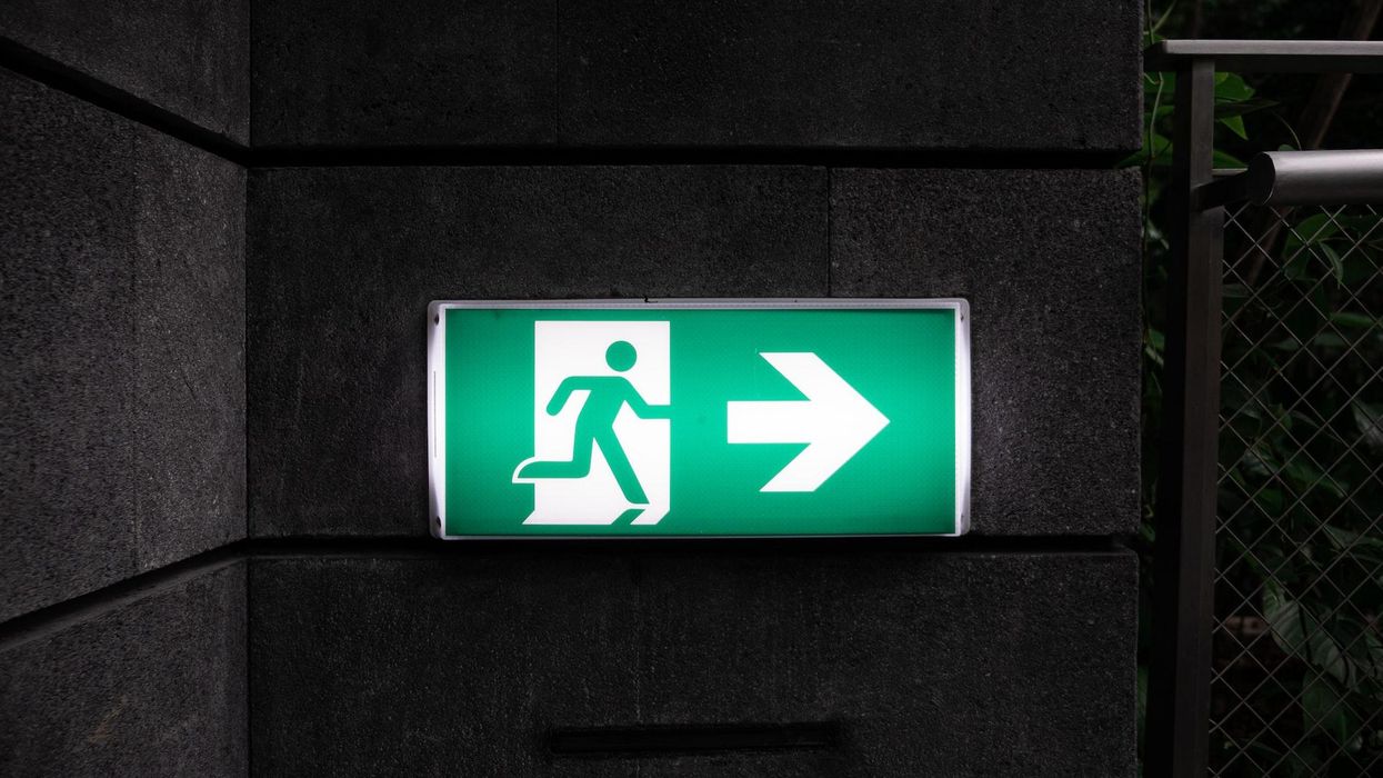 Exit sign of, with a person running away