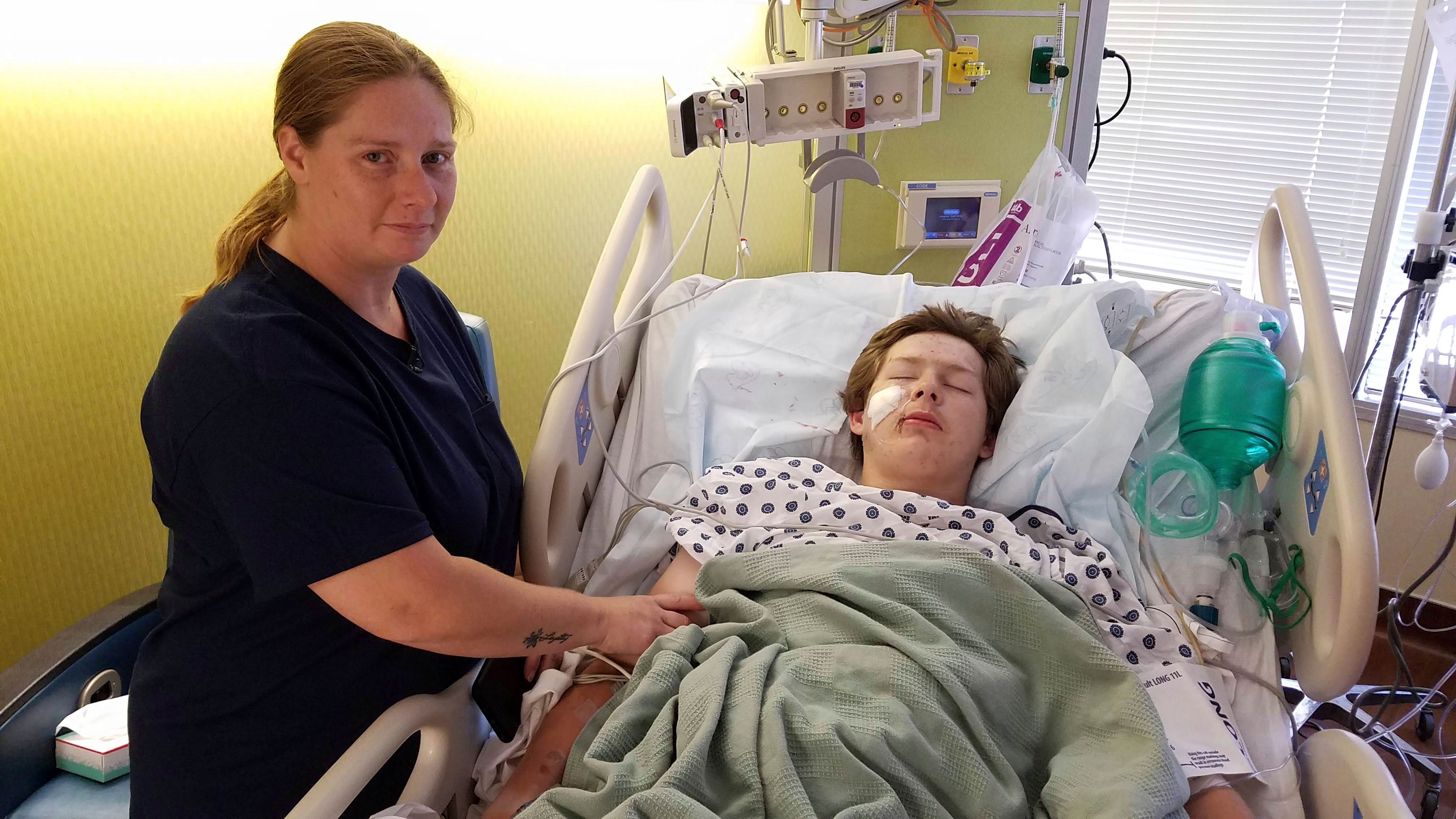 Eli Gregg recovers in the hospital bed in Kansas City, Kan., as his mother Jimmy Russell watches
