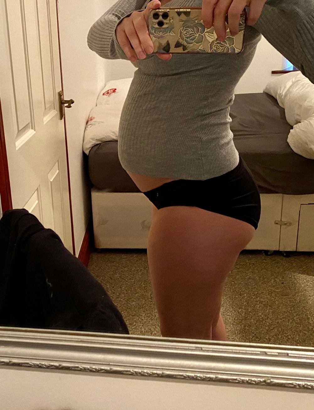 Woman with swollen stomach in mirror