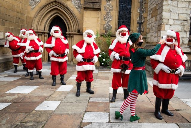 Santas at The Ministry of Fun\u2019s Summer School have their temperature taken at Southwark Cathedral, London which aims to create COVID-safe Christmas grottos by teaching Father Christmases how to appear safely in person whilst maintaining the Christmas magic